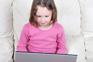 Girl sitting on the sofa and using laptop