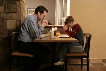 Father And Son Praying Before Meal