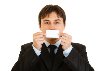 Businessman holding blank business card in front of mouth