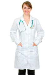 Smiling doctor woman holding hands in pockets of robe