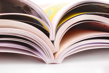 Pile of open magazines isolated on white background