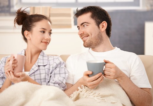 Happy couple drinking tea in bed smiling