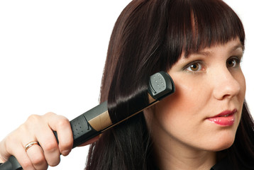 Woman using hair straighteners isolated on white