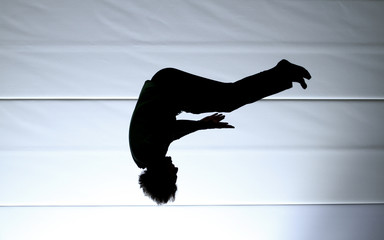silhouette of jumping man doing somersault
