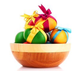 Easter eggs in wooden bowl isolated on white