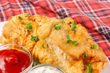 White plate with fried fish, mayonnaise and ketchup