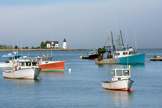 Fishing boats in Inner Harbor and Prospect Harbor Point lighthouse, Maine Atlantic shore, USA
