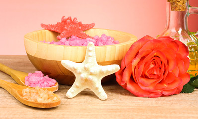 Bath aromatic salt, rose and sea stars on wooden background
