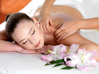 Spa massage on a shoulder for young beautiful woman