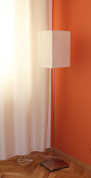 A standing white lamp with a metal base.