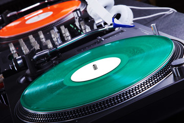 Fototapeta na wymiar Gramofon w disco światła, zielone i czerwone płyty
