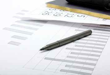 a pen, a notebook and financial statement