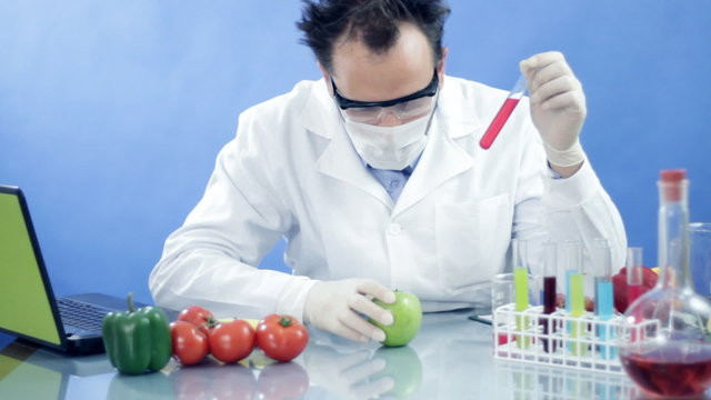 scientist in laboratory examining test tube with red liquid