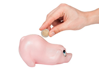 Man's hand inserting 2 euro coin into coin bank