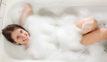 brunette girl washes in a bath