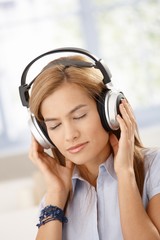 Young woman listening music eyes closed