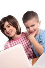 due bambini sorridenti utilizzano computer portatile