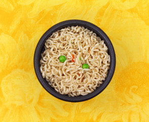 Noodles and vegetables in black bowl
