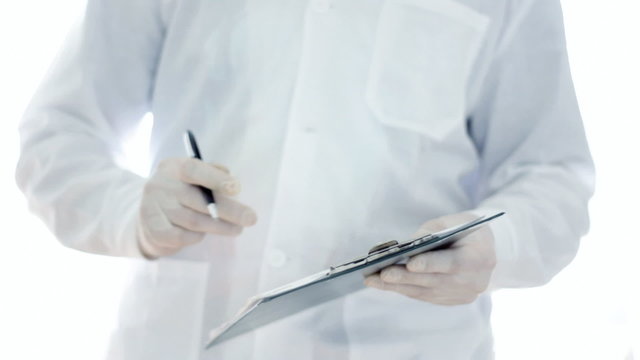 Scientist hands in rubber gloves writing in notepad