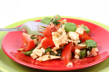 Salad being eaten - farfalle, tomato, salami, mozzarella, basil