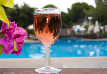 The glass of wine near swimming pool