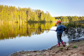 Fototapeta na wymiar Girl on the lake fishing.