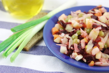 Russian vinaigrette salad, rye bread and spring onions