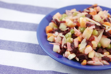 Russian vinaigrette salad in a blue plate on a tablecloth