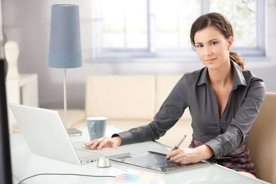 Attractive designer using tablet and laptop