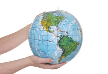Hands holding an inflatable globe showing the American continent