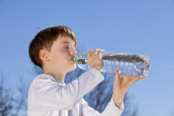 neunjähriger Bub trinkt aus Wasserflasche