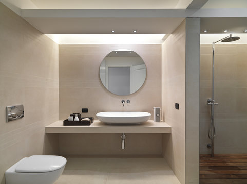 Bagno moderno con rivestimento in marmo e lavabo in ceramica bia