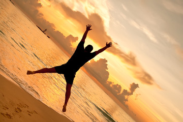 Man jumps in front of sunset on the ocean