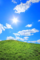 Obraz premium Green grass hills under midday sun