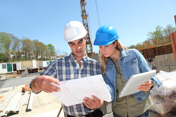 Engineers on construction site with plan