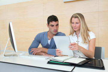 Office workers in office with electronic tablet