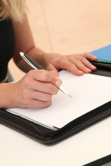 Closeup of woman signing contract