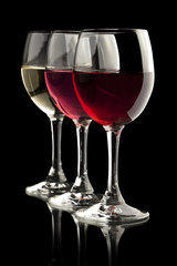 Elegant red, rose and white wine glasses in a black background