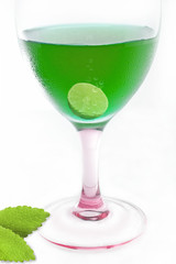 green cocktail with slice lemon on white background