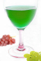 green cocktail with grape on white background