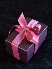 Cadeau violet avec ruban rose sur fond noir