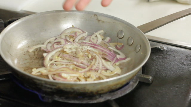 Frying onions with red wine on stove timelapse
