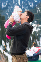 Asian father kissing his baby