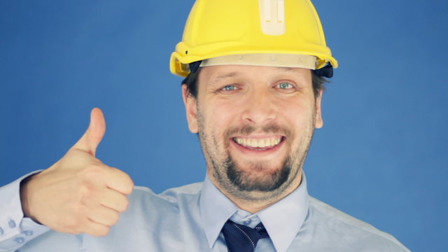 Successful engineer in yellow helmet showing ok sign