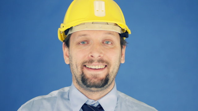 Construction engineer putting on yellow helmet