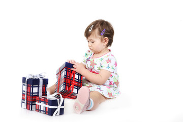 little girl sits with three gift boxes.