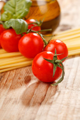 pasta, olive oil and tomatoes on the wood background
