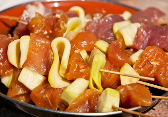 Closeup of marinated chicken meat on skewers (shish kebabs) prep
