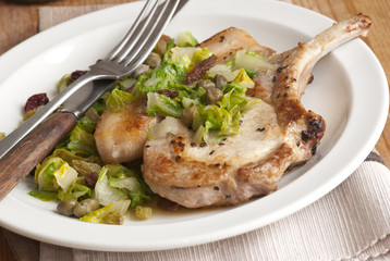 Pork chop with chard, raisins and green sauce