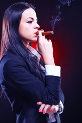 Obraz premium Beautiful elegant young woman with cigar